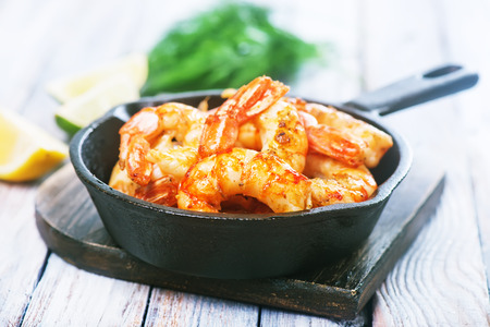 fried shrimps in pan and on a tableの写真素材