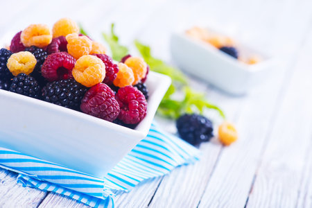 fresh berries in bowl and on a table