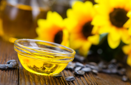 sunflower oil and sunflower seeds on a tableの写真素材