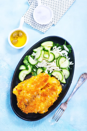 fried fish on plate and on a tableの写真素材
