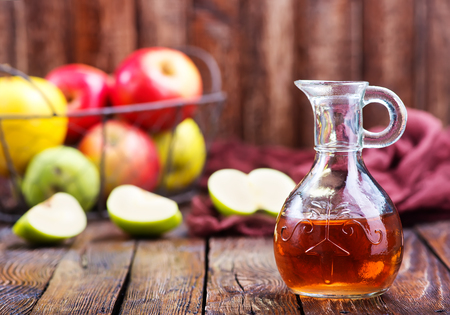 Apple cider vinegar in bottle and on a tableの写真素材