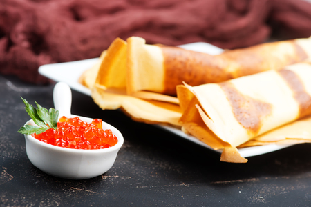 pancakes with caviar on the plate and on a tableの写真素材