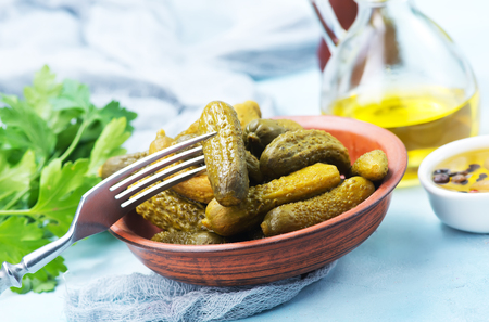 picled cucumber in bowl and on a tableの写真素材