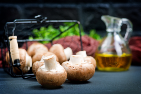 raw mushroom in metal basket and on a tableの写真素材