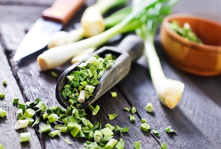 dry green onion and knife on a tableの写真素材
