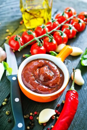 tomato sauce and fresh tomato on a tableの写真素材