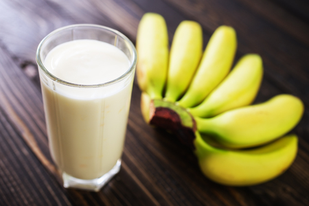 banana yogurt in glass and on a tableの写真素材