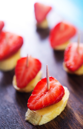 canape with strawberry and banana on wooden boardの写真素材