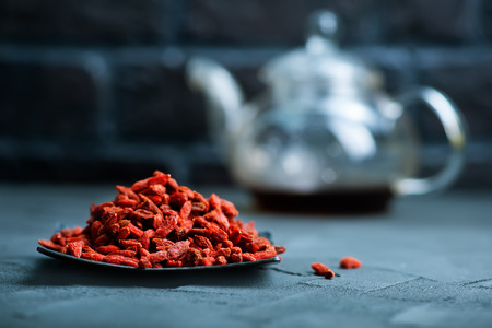 dry goji in bowl and on a tableの写真素材