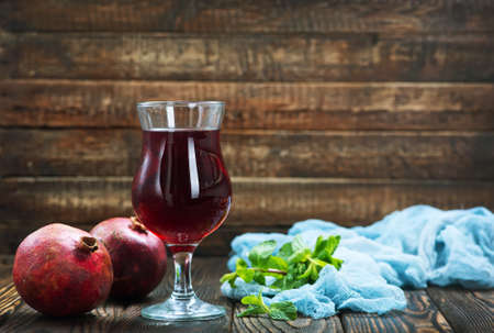 pomegranate juice in glass and on a tableの写真素材