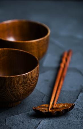 wood bowl with wooden chopsticks on a tableの写真素材