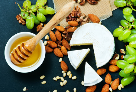 cheese with honey and nuts on a tableの写真素材