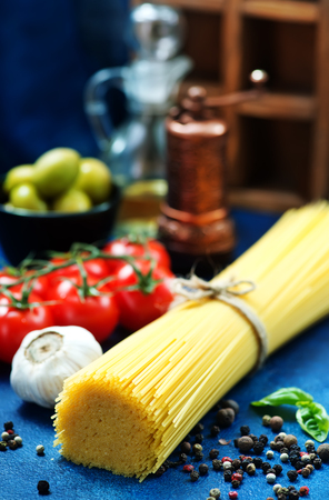 raw pasta with spice and raw tomato on a tableの写真素材