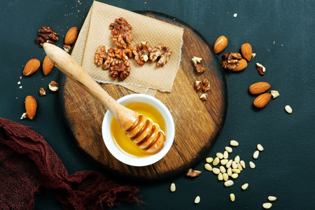 honey with dry almond on a tableの写真素材