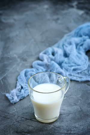 fresh milk in glass and on a tableの写真素材