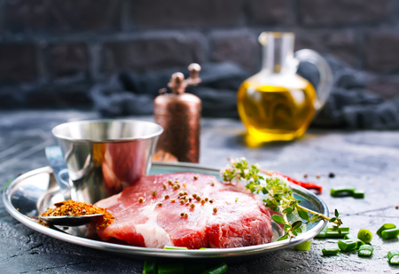 meat with spice on metal plate and on a tableの写真素材