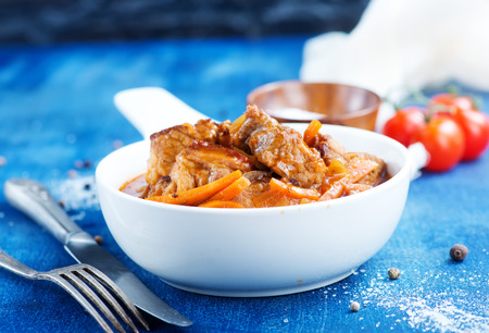 meat stew in white bowl and on a tableの写真素材