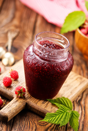 raspberry jam in glass bank on a table