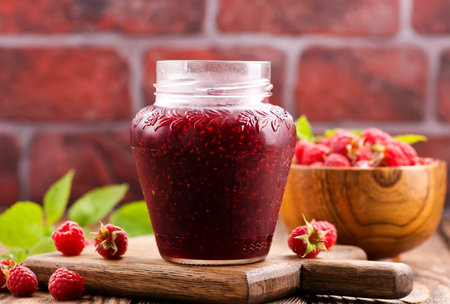 raspberry jam in glass bank on a table