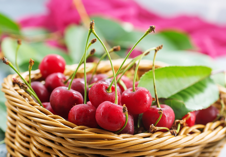 cherry in basket and on a tableの写真素材