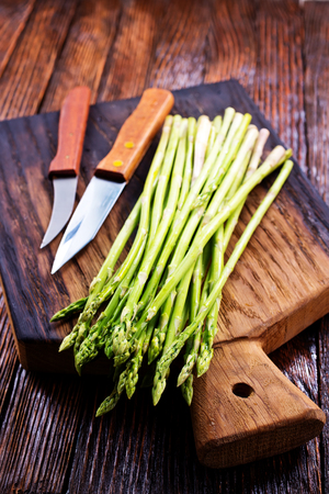 green asparagus on board and on a tableの写真素材