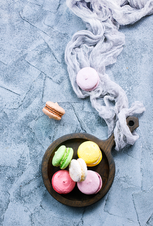 macaroons on wooden plate and on a tableの写真素材