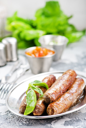 raw sausages with spice on the metal plateの写真素材