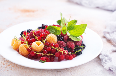 mix berries on plate and on a tableの写真素材