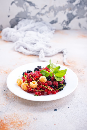mix berries on plate and on a tableの写真素材