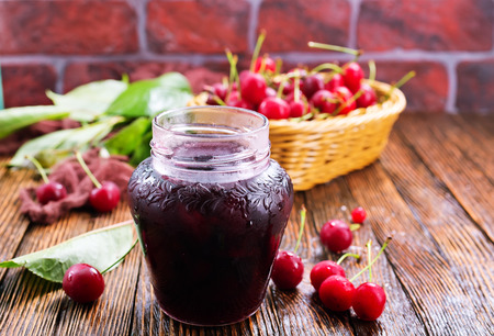 cherry jam in glass bank and on a tableの写真素材