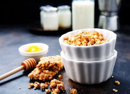 sweet granola with nuts and honey in the bowlの写真素材