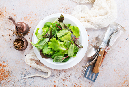 fresh salad in bowl and on a tableの写真素材
