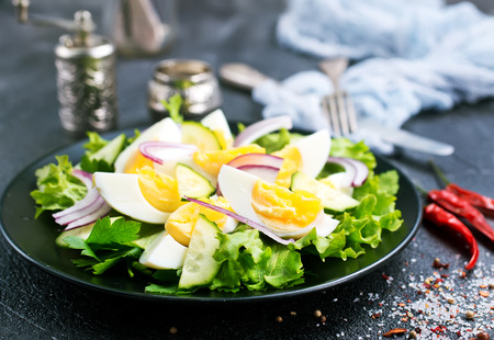 salad with boiled eggs on black plateの写真素材