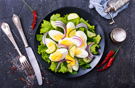 salad with boiled eggs on black plateの写真素材