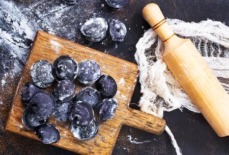 black pelmeni on wooden board, raw pelmeniの写真素材