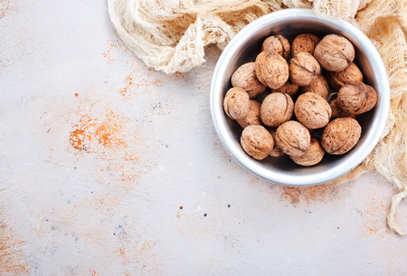 walnuts in bowl and on a tableの写真素材