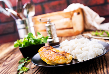 boiled rice with chicken breast on plate on a tableの写真素材