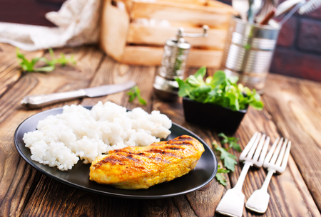 boiled rice with chicken breast on plate on a tableの写真素材