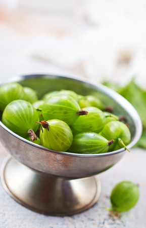 gooseberry in metal bowl, fresh gooseberry on a tableの写真素材