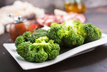 raw meat and fresh broccoli on a tableの写真素材