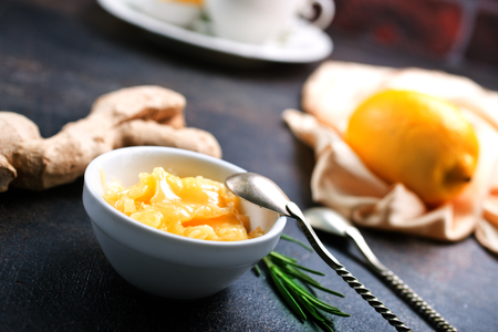 Honey in white bowlr, ginger and lemon on dark backgroundの写真素材