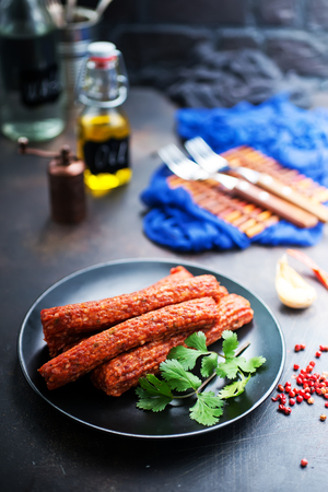 sausages on black plate, smoked sausages, sausages with spiceの写真素材