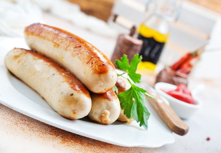 fried sausages with sauce on a tableの写真素材