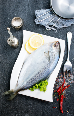 raw fish with fresh lemon on plateの写真素材