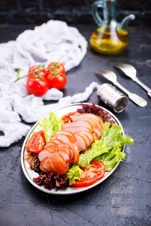 Smoked meat with fresh vegetables on plateの写真素材
