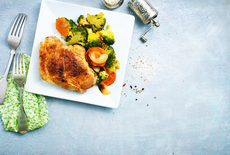 Fried meat with vegetables on white plateの写真素材