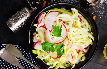 salad from fresh cabbage and radish, salad in black bowlの写真素材