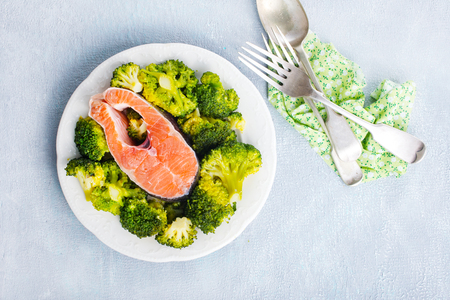 salmon steak with broccoli and spice on plateの写真素材