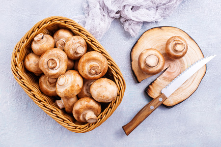 basket of champignon mushrooms on old  tableの写真素材