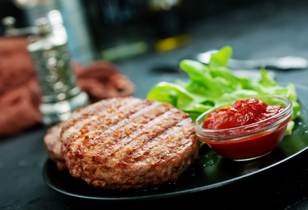 raw burger on plate on a tableの写真素材